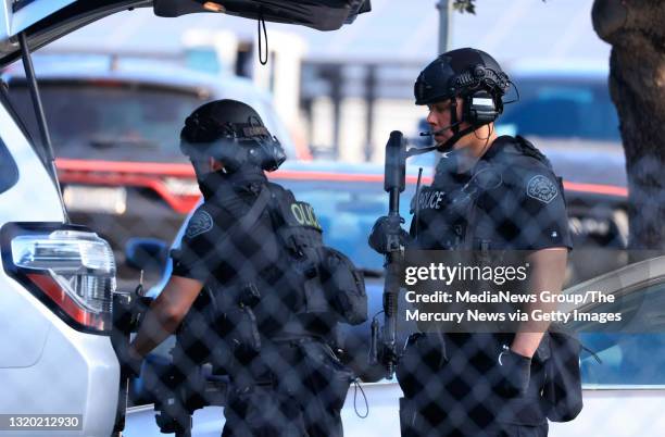 Law enforcement officers retrieve gear from a vehicle near the scene of a mass shooting at the VTA light rail yard in San Jose, Calif., on Wednesday,...