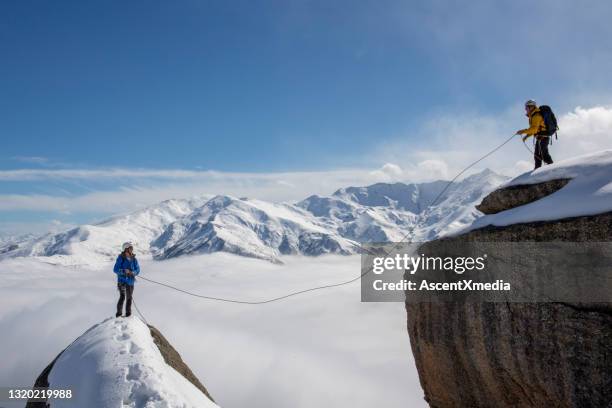 l’alpiniste lance une corde pour s’associer depuis le sommet - rope high rescue photos et images de collection