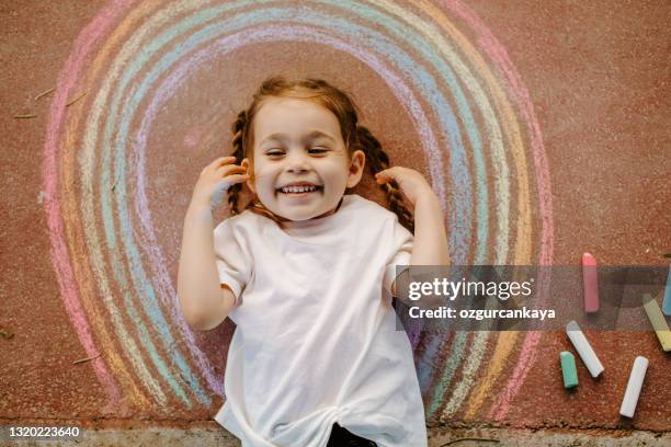 child drawing rainbow with chalk - chalk art equipment stock pictures, royalty-free photos & images