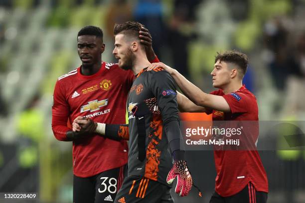 David De Gea of Manchester United is consoled by teammates Axel Tuanzebe and Daniel James following their team's defeat in the penalty shoot out...