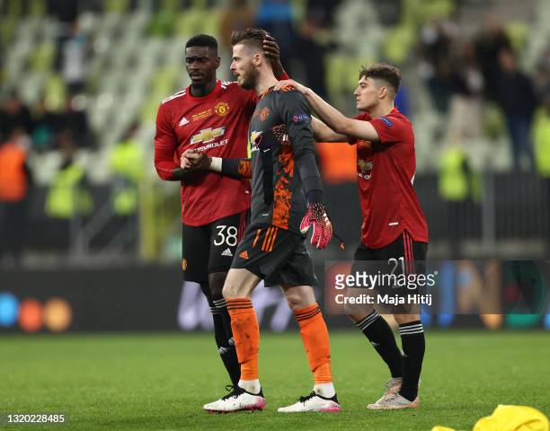 David De Gea of Manchester United is consoled by teammates Axel Tuanzebe and Daniel James following their team's defeat in the penalty shoot out...