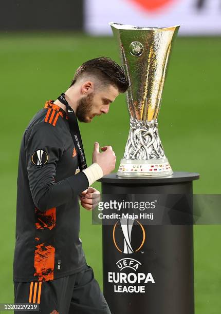David De Gea of Manchester United removes their medal as they make their way past the UEFA Europa League Trophy following the UEFA Europa League...