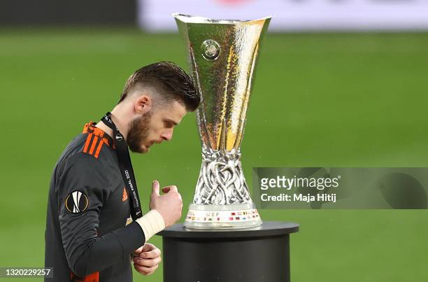 David De Gea of Manchester United removes their medal as they make their way past the UEFA Europa League Trophy following the UEFA Europa League...