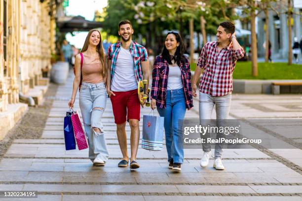 young people shopping in the mall in front of a fashion shop - skateboard shop stock pictures, royalty-free photos & images