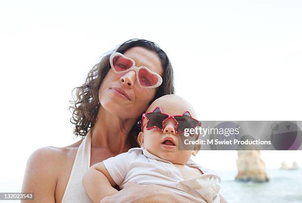 mother holding her son at beach - baby m stock pictures, royalty-free photos & images