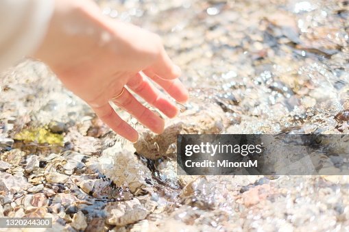 A hand touching stream A hand touching stream