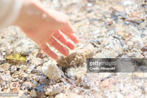 a hand touching stream - bright future stock pictures, royalty-free photos & images
