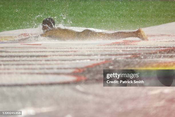 Streaker slides on the infield tarp during a rain delay between the Cincinnati Reds and against the Washington Nationals at Nationals Park on May 26,...