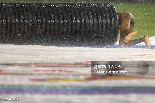 Streaker slides on the infield tarp into the tarp roller during a rain delay between the Cincinnati Reds and against the Washington Nationals at...