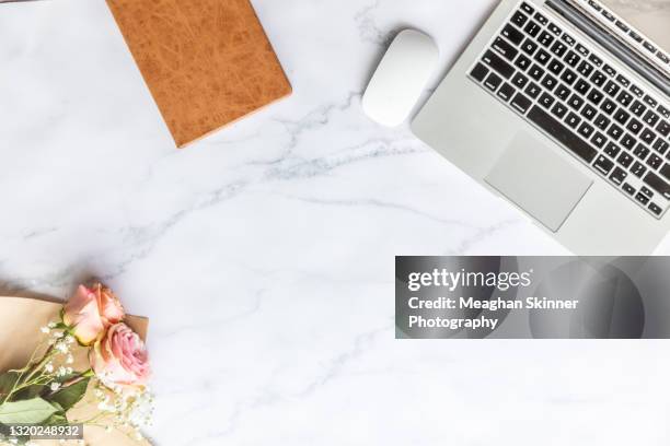 laptop, notebook and flowers on a white marbled background - white flower paper stock pictures, royalty-free photos & images