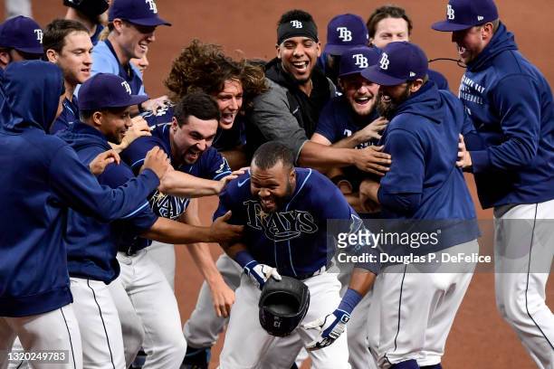 Manuel Margot of the Tampa Bay Rays is mobbed by his teammates after hitting an RBI single during the tenth inning to defeat the Kansas City Royals...