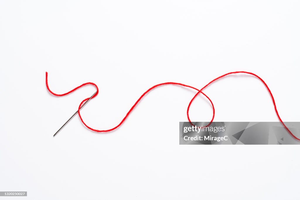 Curved Red Thread Through The Sewing Needle High-Res Stock Photo - Getty  Images