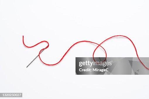 Curved Red Thread Through the Sewing Needle Curved Red Thread Through the Sewing Needle