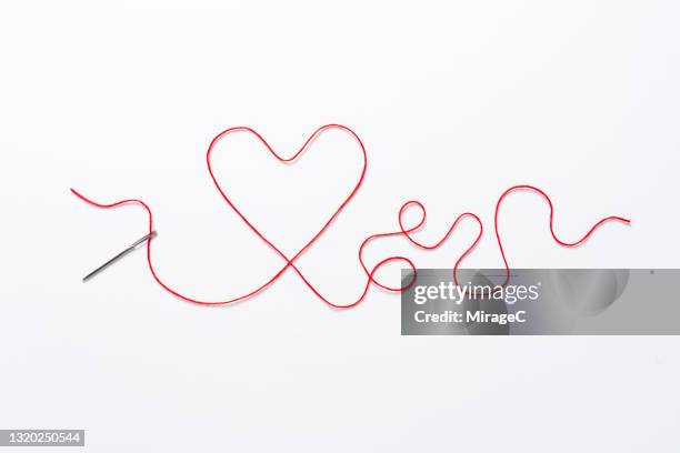 heart shape red thread through the sewing needle love concept - string art stock pictures, royalty-free photos & images