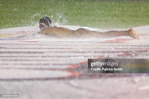 Streaker slides on the infield tarp during a rain delay between the Cincinnati Reds and against the Washington Nationals at Nationals Park on May 26,...