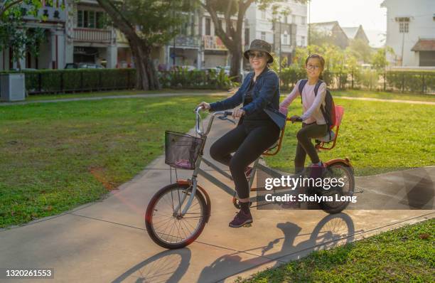 ciclismo de relajación de madre e hija asiática - ciclismo tandem fotografías e imágenes de stock