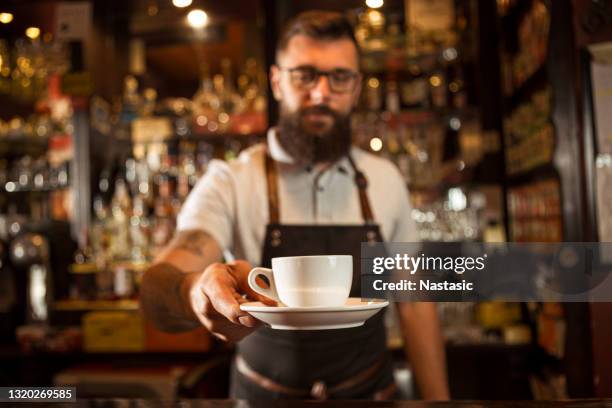 bartender offering coffee to a customer - barista stock pictures, royalty-free photos & images