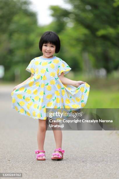 lovely mixed race little girl in one piece dress - girl in yellow dress stock pictures, royalty-free photos & images