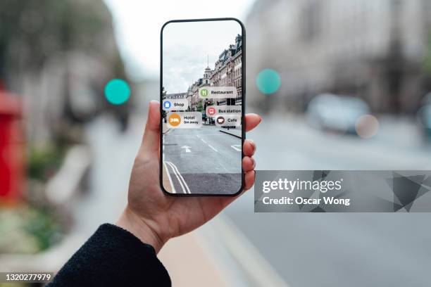 finding direction with augmented reality on smartphone on street - augmented reality woman stock-fotos und bilder