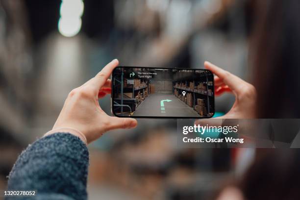 finding direction with augmented reality on smartphone at retail store - digital shopping foto e immagini stock