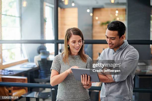 オフィスのデジタルタブレットで一緒に働く2人のビジネスマンのショット - using digital tablet ストックフォトと画像