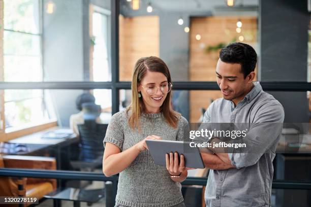 ontsproten van twee zakenlieden die aan een digitale tablet in een bureau samenwerken - twee personen stockfoto's en -beelden