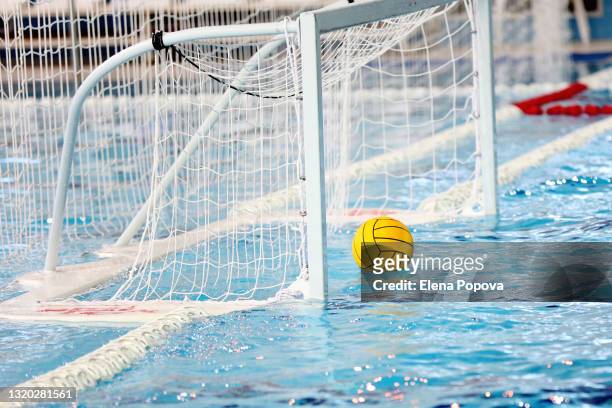 yellow water polo ball floating on the water into  water polo goal net - waterpolo imagens e fotografias de stock