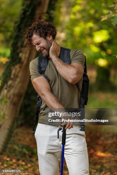 man is traveling with backpack and has problems with insects in the forest. - mosquito bite stock pictures, royalty-free photos & images