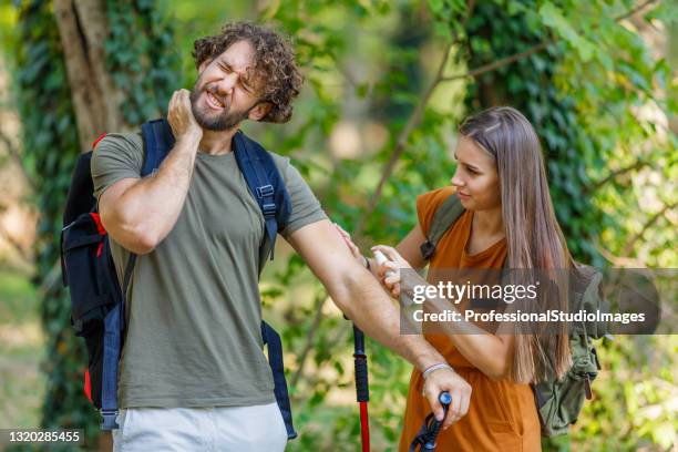 o homem e sua esposa estão coçando a pele coceira devido ao ataque de insetos na natureza. - tick bite - fotografias e filmes do acervo