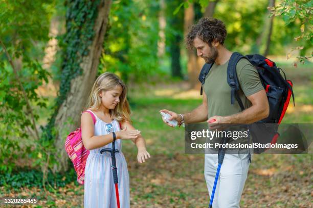 man and his daughter are scratching itchy skin due to the attack of insects in nature. - killing insects stock pictures, royalty-free photos & images