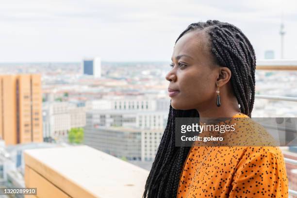 portret van zwarte bedrijfsvrouw bij dak in berlijn - berlin diversity alexanderplatz stockfoto's en -beelden