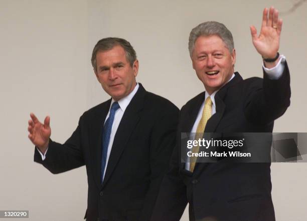 President Bill Clinton, right, and president-elect George W. Bush wave before their meeting December 19, 2000 at the White House in Washington, DC.