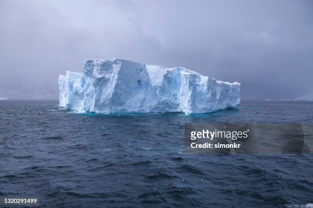 blick auf riesige kathedrale wie eisberg auf antarktischem ozean schwimmen - ice shelf stock-fotos und bilder