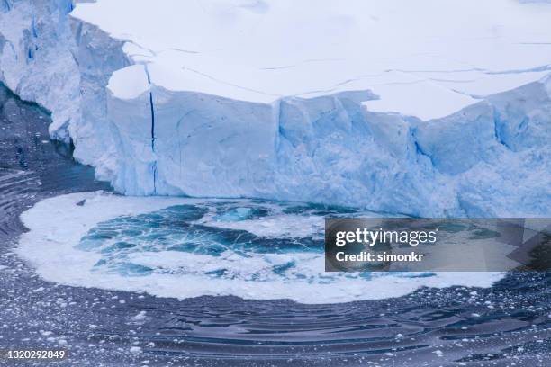 high angle view of glacier collapsing on antarctic ocean - glacier calving stock pictures, royalty-free photos & images