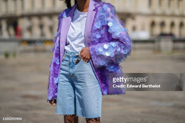 Emilie Joseph @in_fashionwetrust wears a crystal matching ring, a white t-shirt, a pale purple oversized long blazer jacket with embroidered plastic...