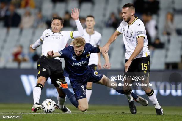 Matt Simon of the Mariners is tackled by Mark Milligan and Aleksandar Susnjar of the Bulls during the A-League match between Macarhut FC and the...