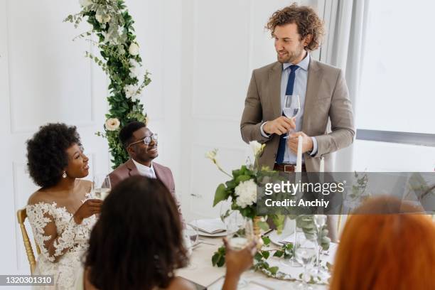 bester mann gibt einen toast und rede bei einer hochzeitsfeier - trauzeuge des bräutigams stock-fotos und bilder