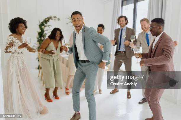 young newlywed couple dancing alongside their guests on their wedding day - black couple wedding stock pictures, royalty-free photos & images