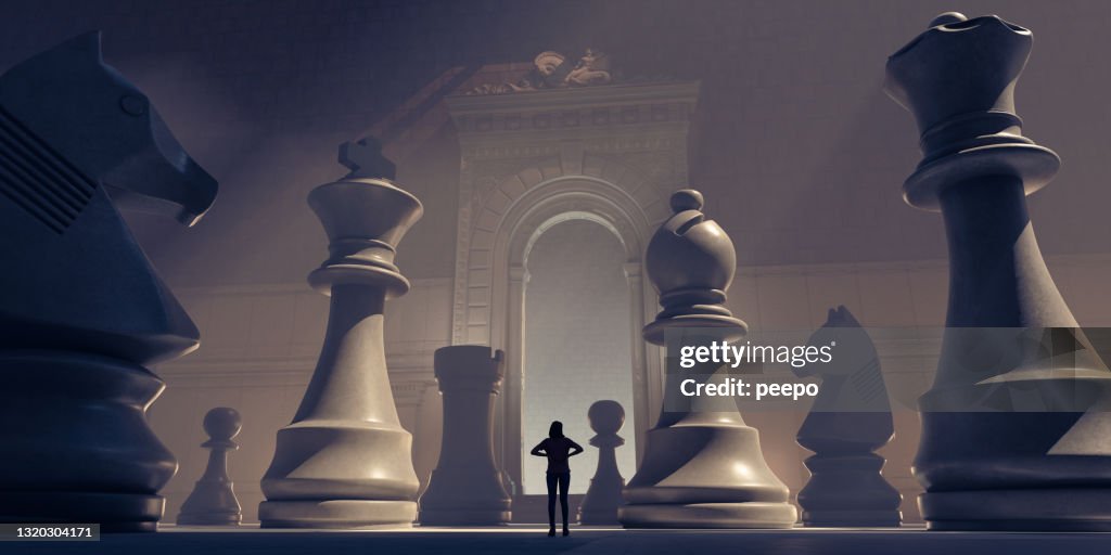 Small Female Figure Surrounded By Huge Chess Pieces Within An Ornate Old Building