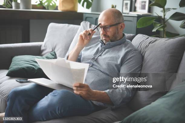 mature adult man working from home office (paperwork, negative emotion ) - bankruptcy stock pictures, royalty-free photos & images