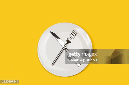 Fork and knife crossed on a white plate Fork and knife crossed on a white plate