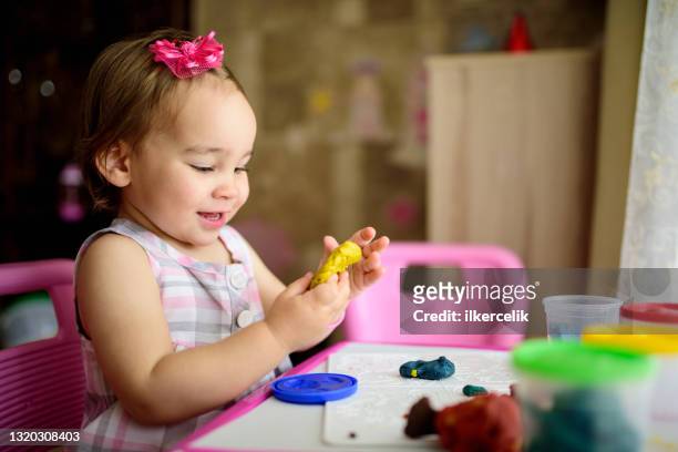 baby girl playing with putty at home - baby imagination stock pictures, royalty-free photos & images