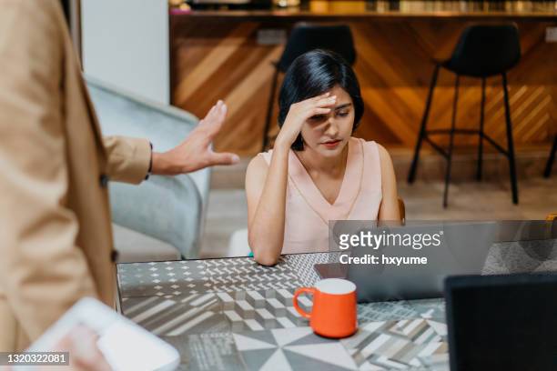 stressed asian female worker in business meeting - angry colleague stock pictures, royalty-free photos & images