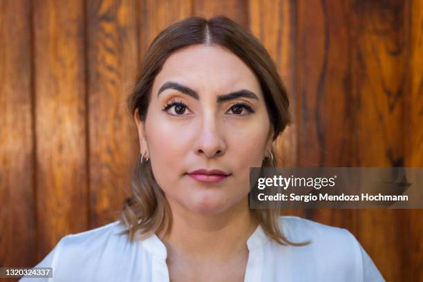 young latino woman raising an eyebrow and looking at the camera - suspicion 個照片及圖片檔