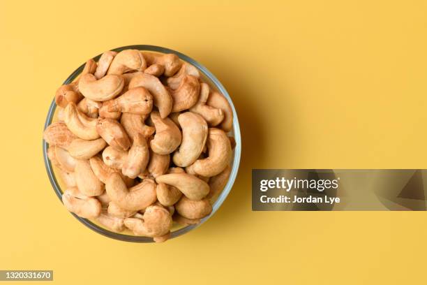 flat lay of cashew in glass bowl - cashewnuss stock-fotos und bilder