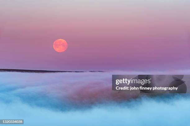 super flower blood moon over morning fog, peak district national park. - peak district national park spring stock pictures, royalty-free photos & images