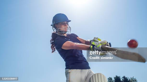 weibliche batsman schlagen den ball mit ihrem schläger - cricketer stock-fotos und bilder