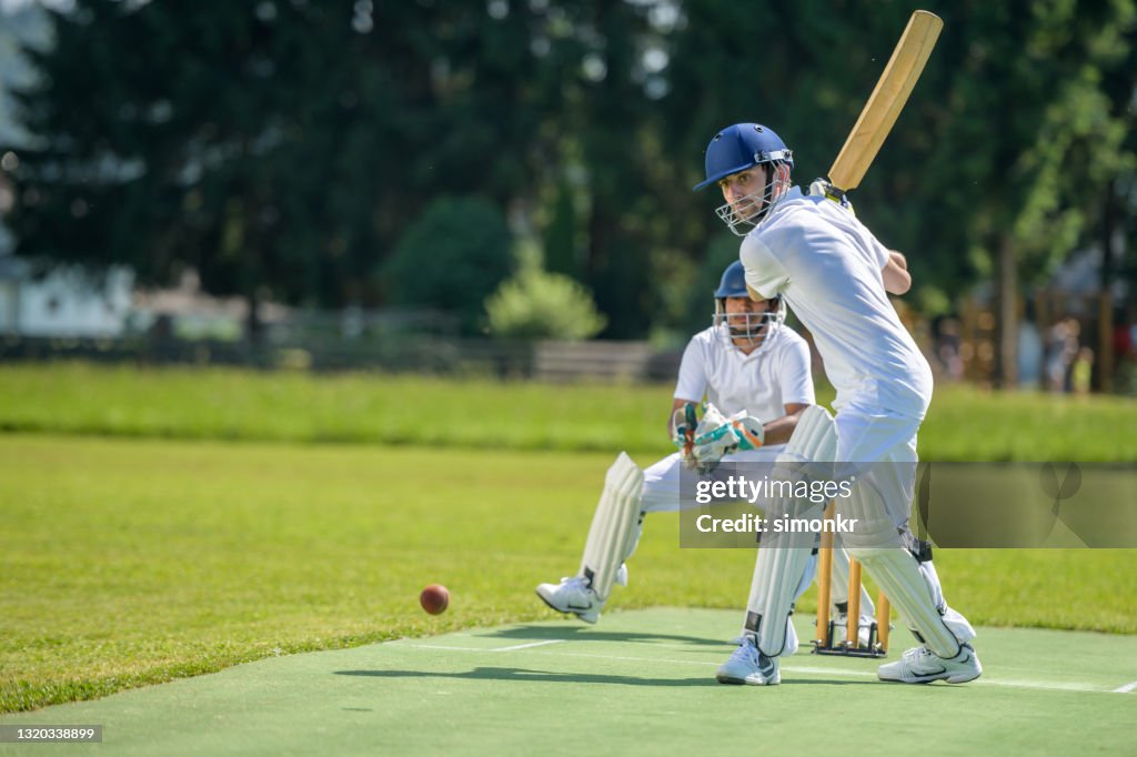 Batsman hitting ball on pitch