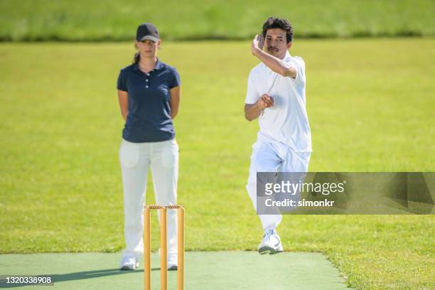 männliche bowler bowling auf dem feld - cricket bowler stock-fotos und bilder