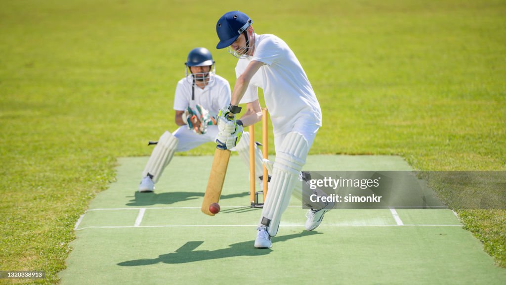 Batsman hitting ball on pitch